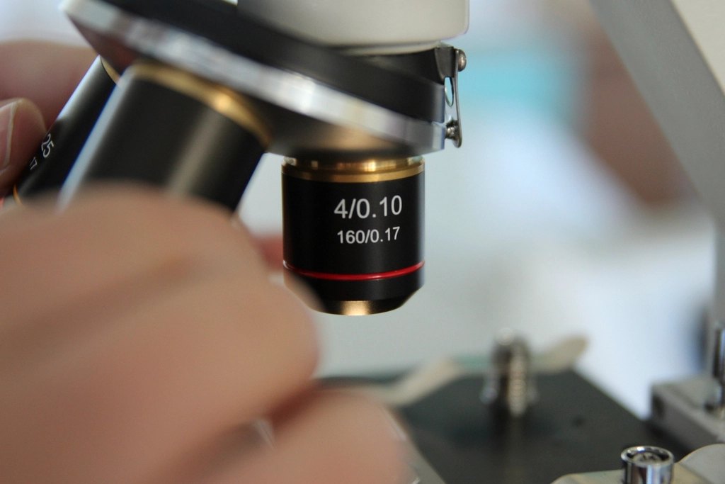 A close-up of a microscope objective lens while a sample is being examined