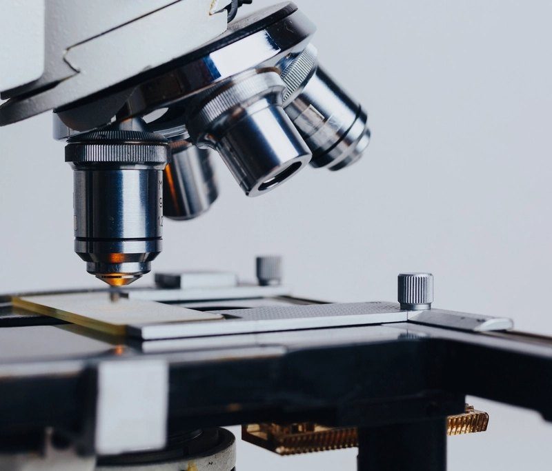 A laboratory microscope photographed against a dark background