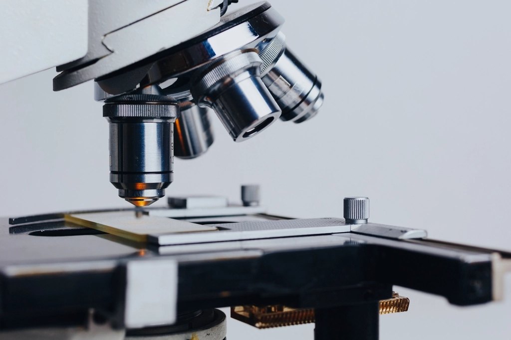 A laboratory microscope photographed against a dark background