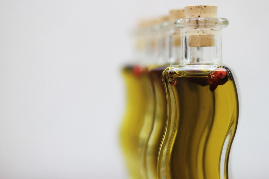 Several corked bottles of olive oil photographed in a row with a shallow depth of field