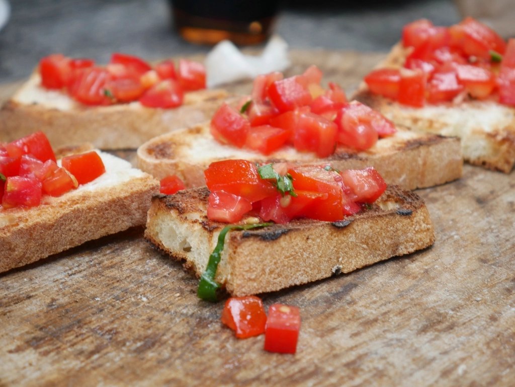 Slices of toasted bread topped with diced tomato and olive oil