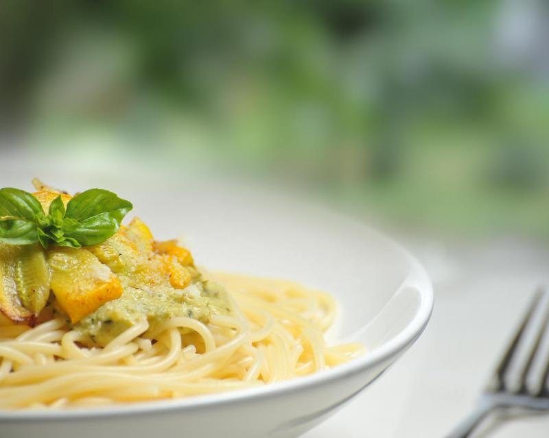 A plate of spaghetti tossed with olive oil and fresh basil