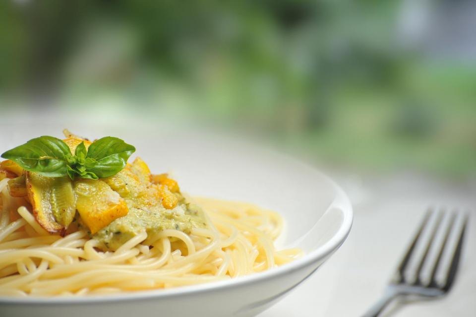 A plate of spaghetti tossed with olive oil and fresh basil